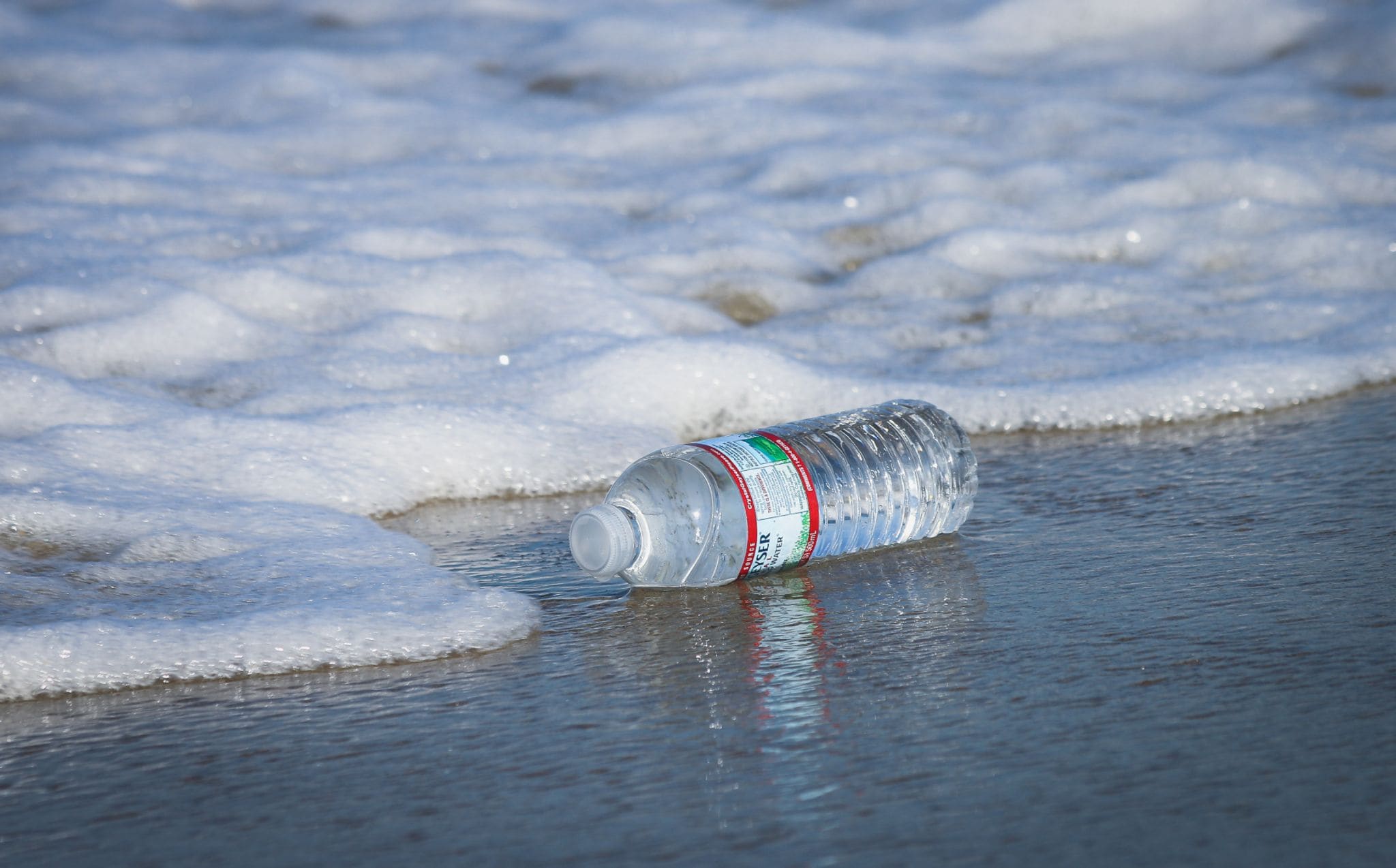 A clear PET bottle at the water’s edge